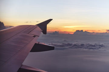 Fototapeta na wymiar flying aircraft wing on beautiful sunset