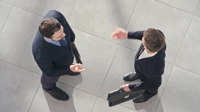 Directly above view of two businessmen talking about something and then shaking hands