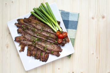 Baked Peppercorn Bacon in square white ceramic plate