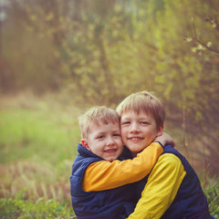 Fototapeta premium Portrait happy two brothers embracing in sunny day.