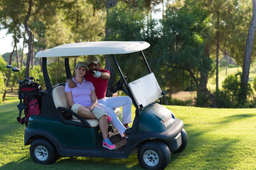 couple in buggy on golf course