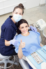 Women patient giving thumbs up at the dentist chair