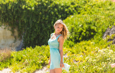 Naklejka na ściany i meble Portrait of young beautiful blonde woman, on green background summer nature