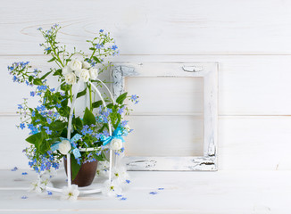 Forget-me-not flowers with birdcage and photo frame