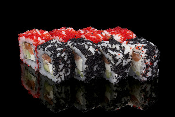 Japanese cuisine. Sushi roll with red and black tobiko over black background.