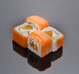 Japanese cuisine. Salmon sushi roll over black background.