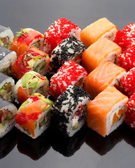 Japanese cuisine. Sushi set over black background.
