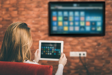 Closeup of a tablet is connected to a smart TV. - obrazy, fototapety, plakaty