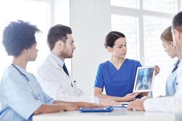 group of doctors with x-ray on tablet pc at clinic