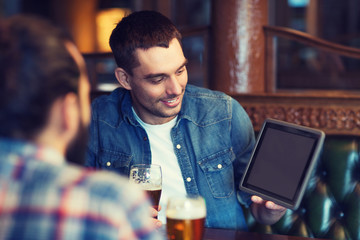 male friends with tablet pc drinking beer at bar