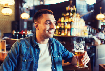 happy man drinking beer at bar or pub