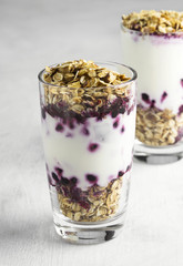 Useful dessert of granola, yogurt and blueberry in glass on a wh