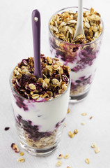 Useful dessert of granola, yogurt and blueberry in glass on a wh