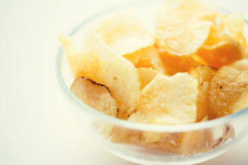 close up of crunchy potato crisps in glass bowl