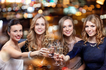 happy women with champagne glasses at night club