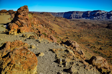 petrified lava flows in the desert valley of Teide volcano caldera with snow covered Montanas del Teide in the background