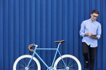 Modern man with tablet and bike
