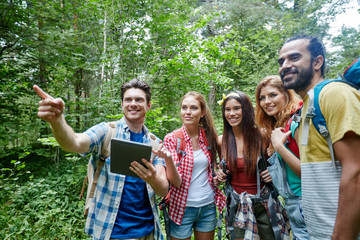 happy friends with backpacks and tablet pc hiking