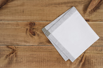 Above view of folded linen napking on wooden texture background