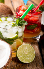 Mojito limea and strawberry drinks on wood with blur beach background