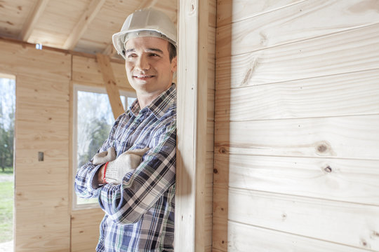 Contractor leaning against wooden wall