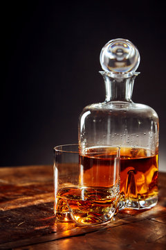 Glass Of Whisky Besides Decanter On A Round Table