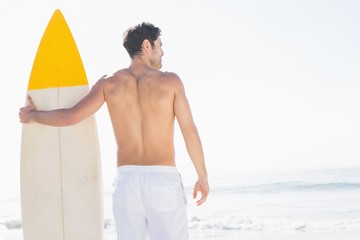 Man holding surfboard on the beach