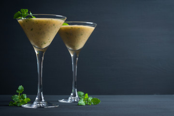Fresh banana cocktail with mint on the black wooden background