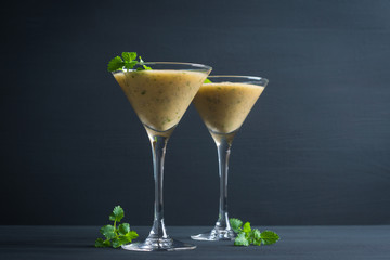 Fresh banana cocktail with mint on the black wooden background