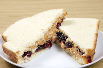 Peanutbutter and Jelly Sandwich cut in half served on plate on w