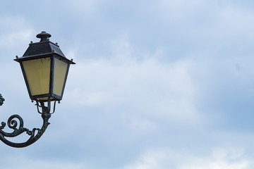 Fototapeta na wymiar Street lamp against the blue cloudy sky