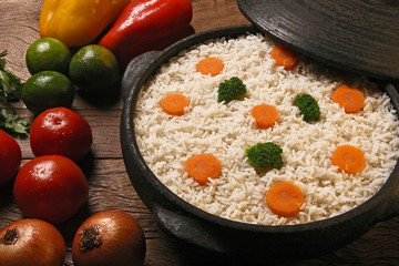 Appetizing healthy rice with vegetables in white plate on a wood