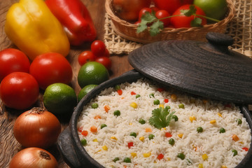 Appetizing healthy rice with vegetables in white plate on a wood