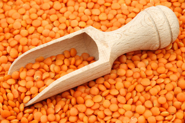red lentils with a wooden scoop background