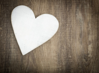 Wooden heart on brown wood plank background