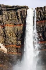 The Hengifoss waterfall in Iceland with red strata stripes
