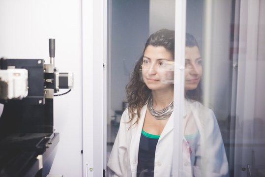 Female scientist monitoring motor alignment on x-ray diffractometer machine