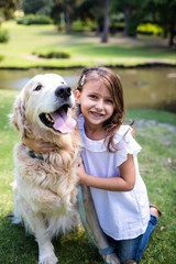 Smiling girl with her pet dog in the park