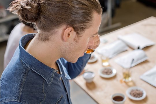 Coffee taster sipping coffee with spoon