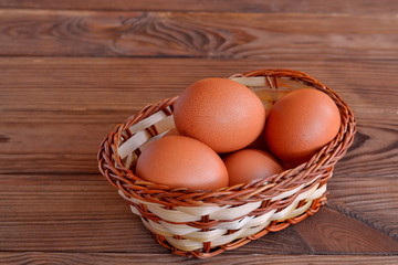 Chicken eggs in a basket. Set the raw chicken eggs. Wooden table