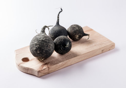 black beet radish group on wooden cutting board and white background