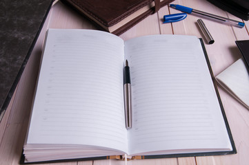 old leather notebook and fountain pen on wooden boards