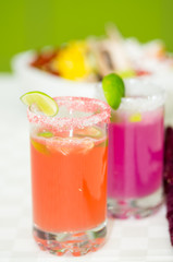 Fototapeta premium Closeup small sugarcoated shotglasses with delicious orange and purple juices inside
