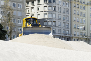 excavator  on the city  beach working moving the sand