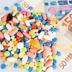 Fototapeta na wymiar Pills of different colors on money