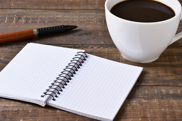 blank notebook, pen and cup of coffee