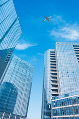 low angle view of airplane flying over skyscrapers,shanghai china.