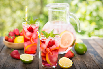 Pink lemonade with lemon, lime and strawberries 