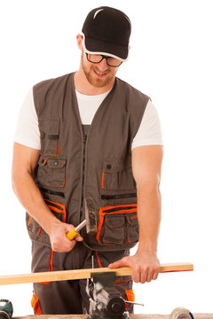 Handyman in work clothing hammering nail with hammer in home wor