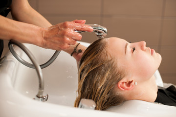 Obraz na płótnie Canvas Hair stylist at work - hairdresser washing hair to the customer